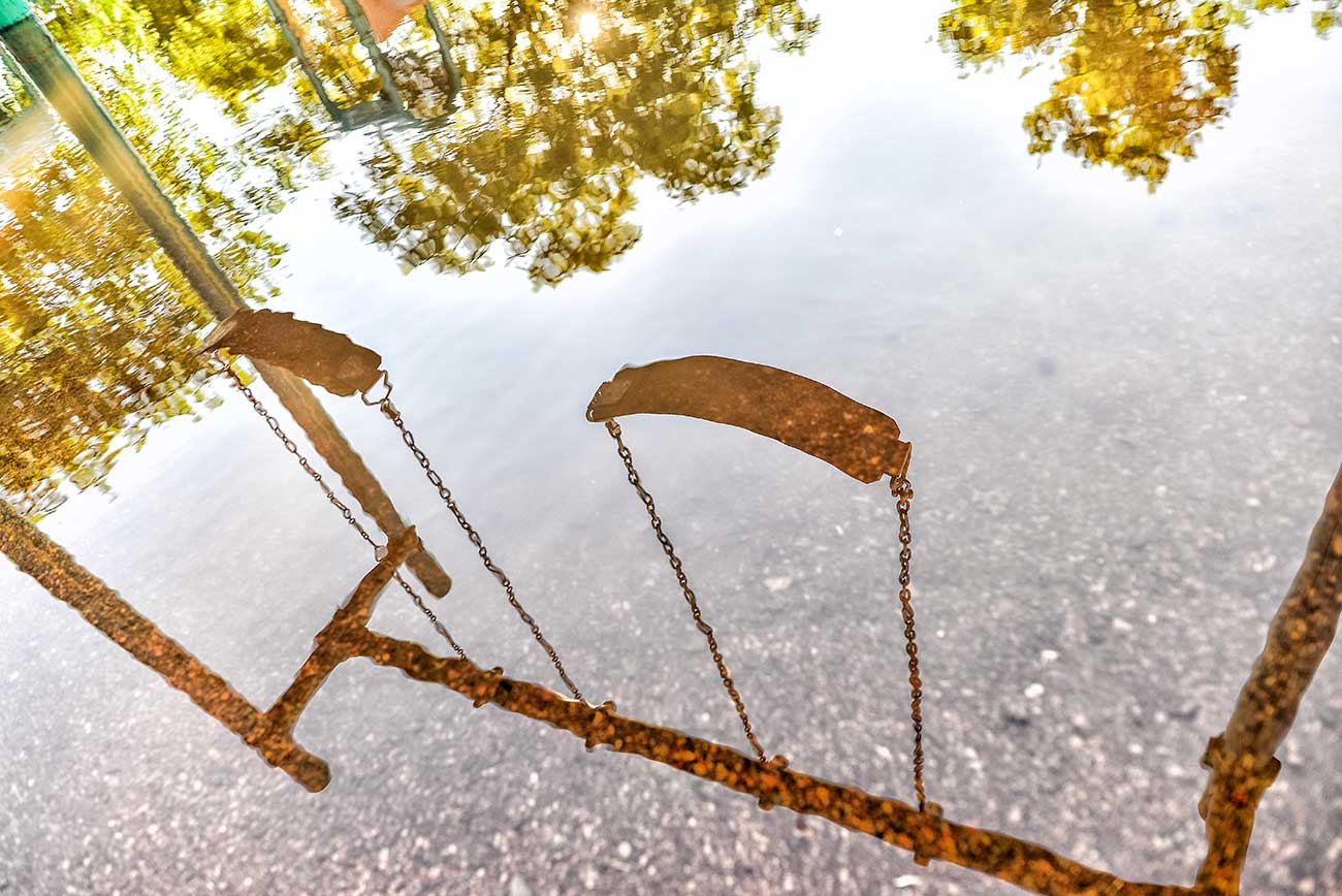 Reflektion av gungställning i vatten.