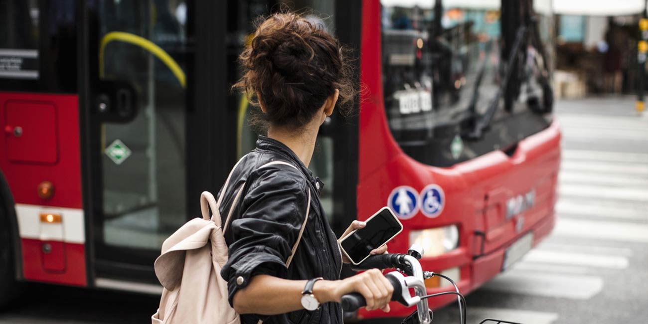 Kvinna med cykel i pendlingstrafik.