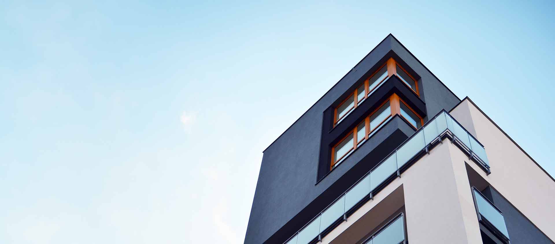Modern byggnad fotograferad från marken upp mot en ljudblå himmel.