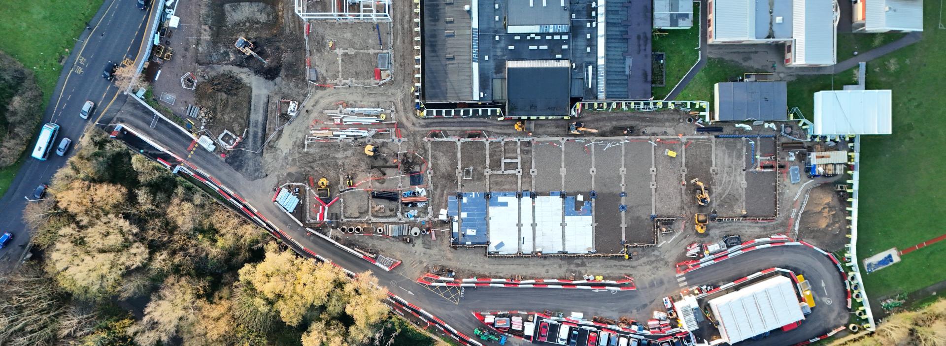Aerial view of an active construction site with roadworks, buildings and infrastructure development in progress