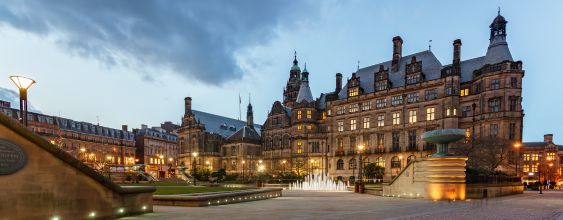 A picture of Sheffield Town Hall in Yorkshire in England. A large gothic building with a public pedestrianised square in front of it.