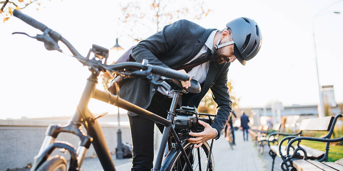 Affärsman elcykelpendlar till jobbet.