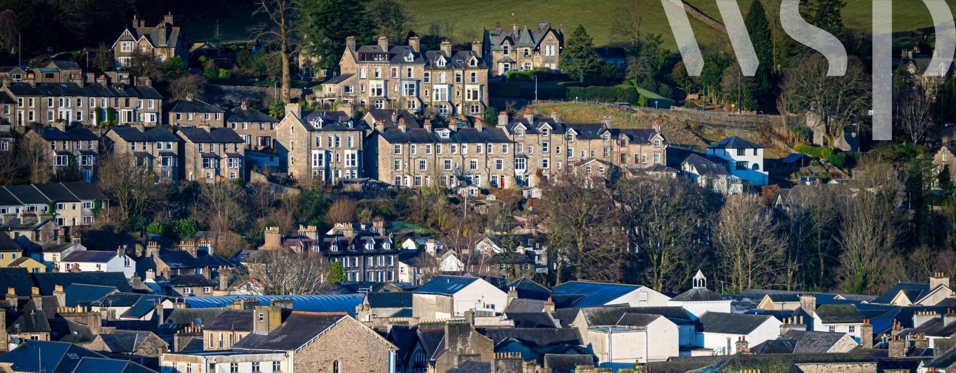 View of suburban houses in British town Kendal, with clear white WSP logo in upper right corner. 