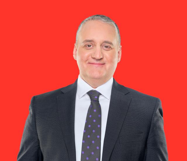Professional headshot of a person against a red background