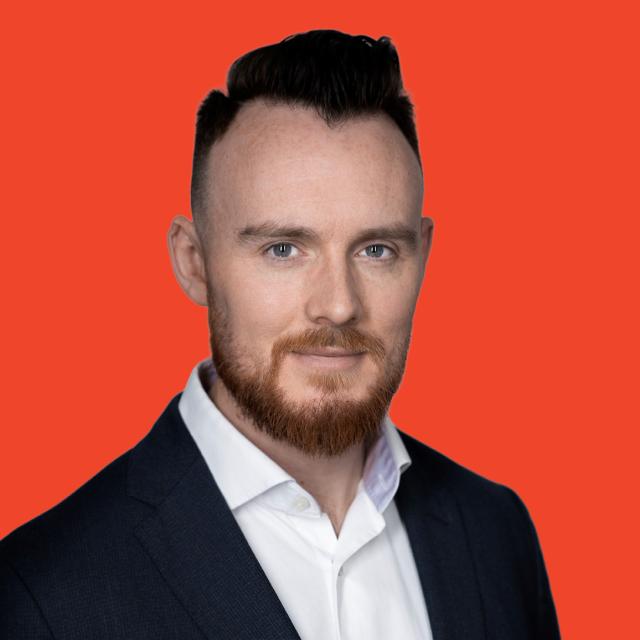 Professional headshot of a person against a red background