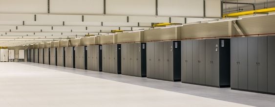 Data center corridor with rows of gray server cabinets in a clean, modern facility.