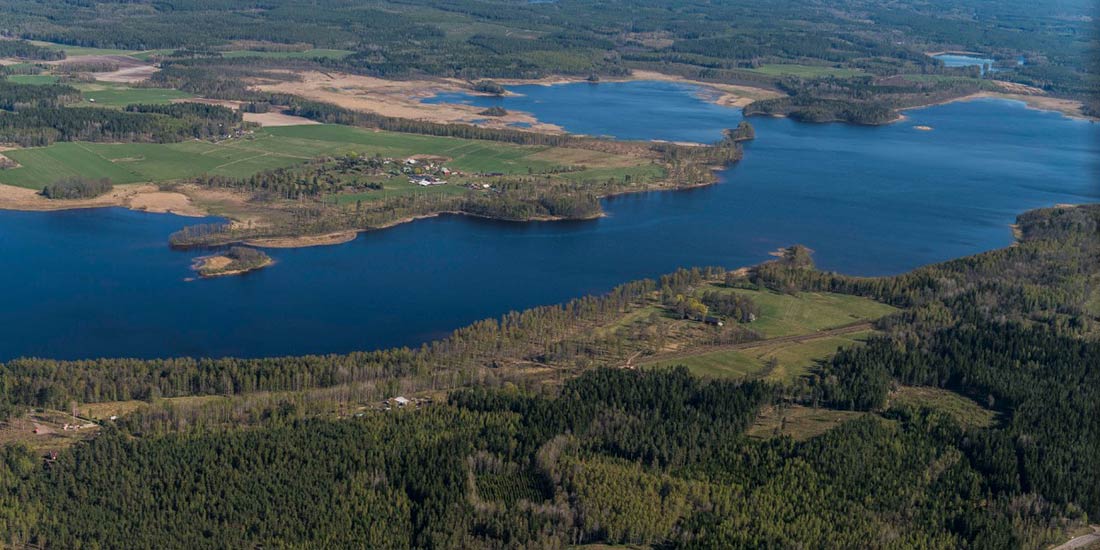 Fågelvy över Hultsfred 3:1, Herrstorpet, som visar på gård, åkermark, skog och sjöar.