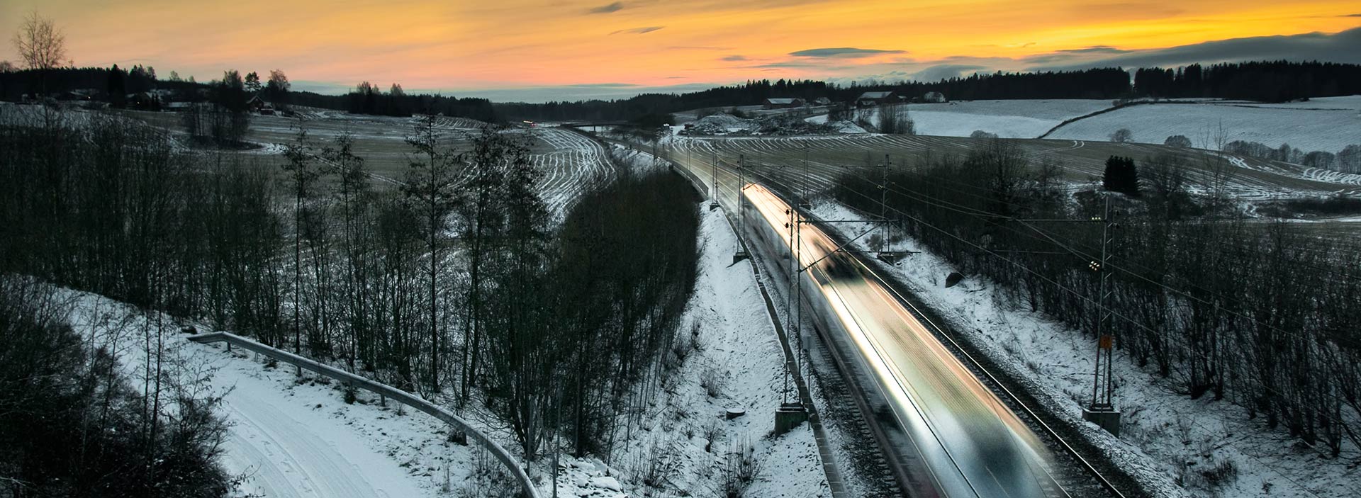 Snabbtåg åker genom vinterlandskap.