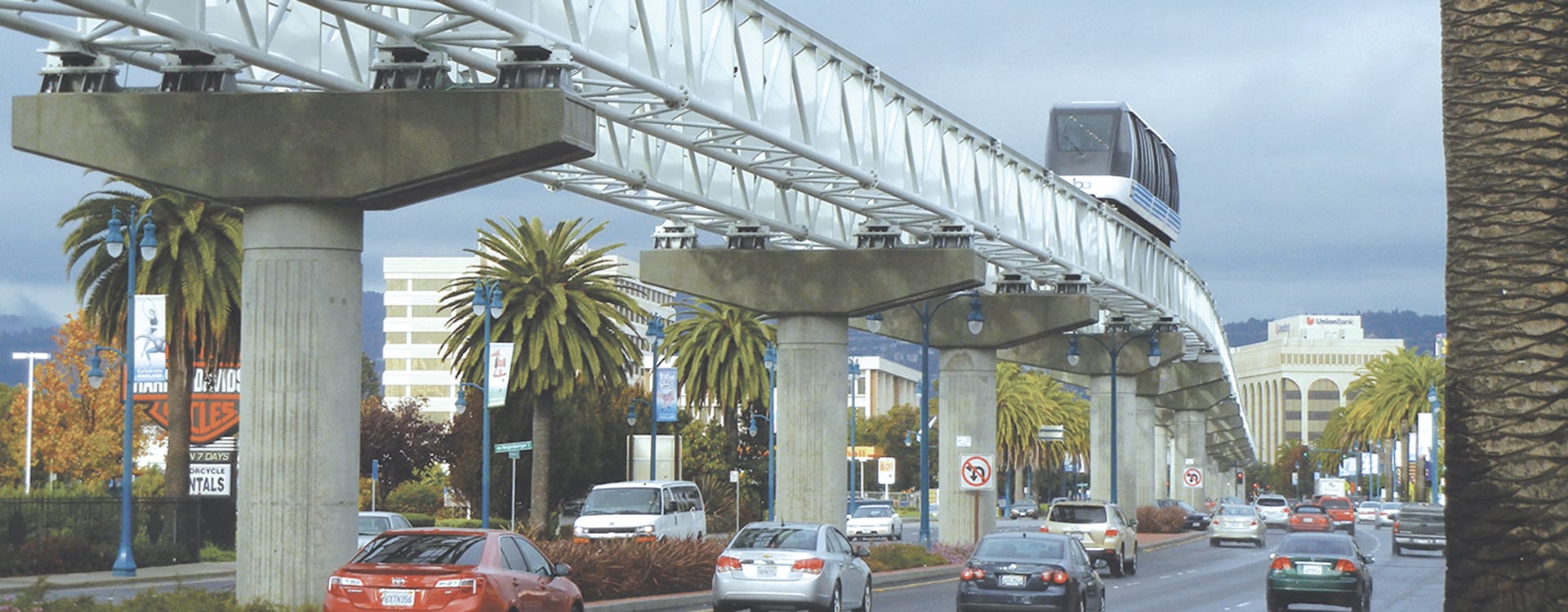 Long view of the BART airport connector running parallel and to the traffic below