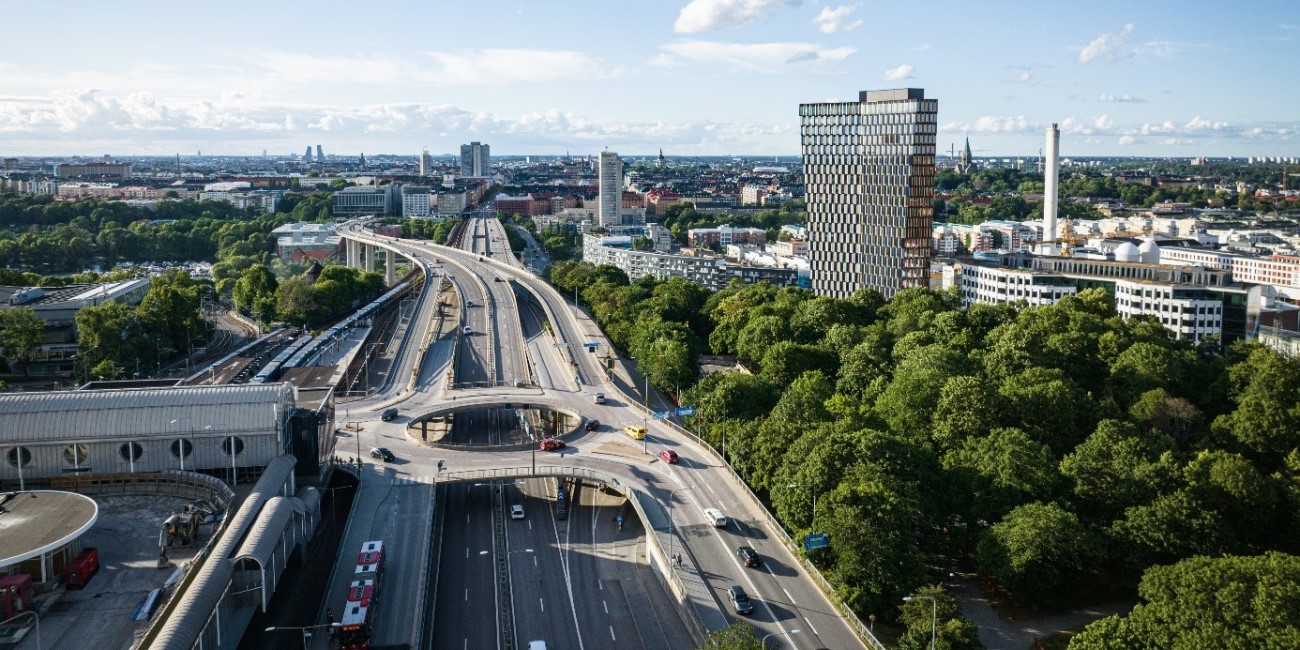 Vy Stockholm med bilväg, skog och byggnader